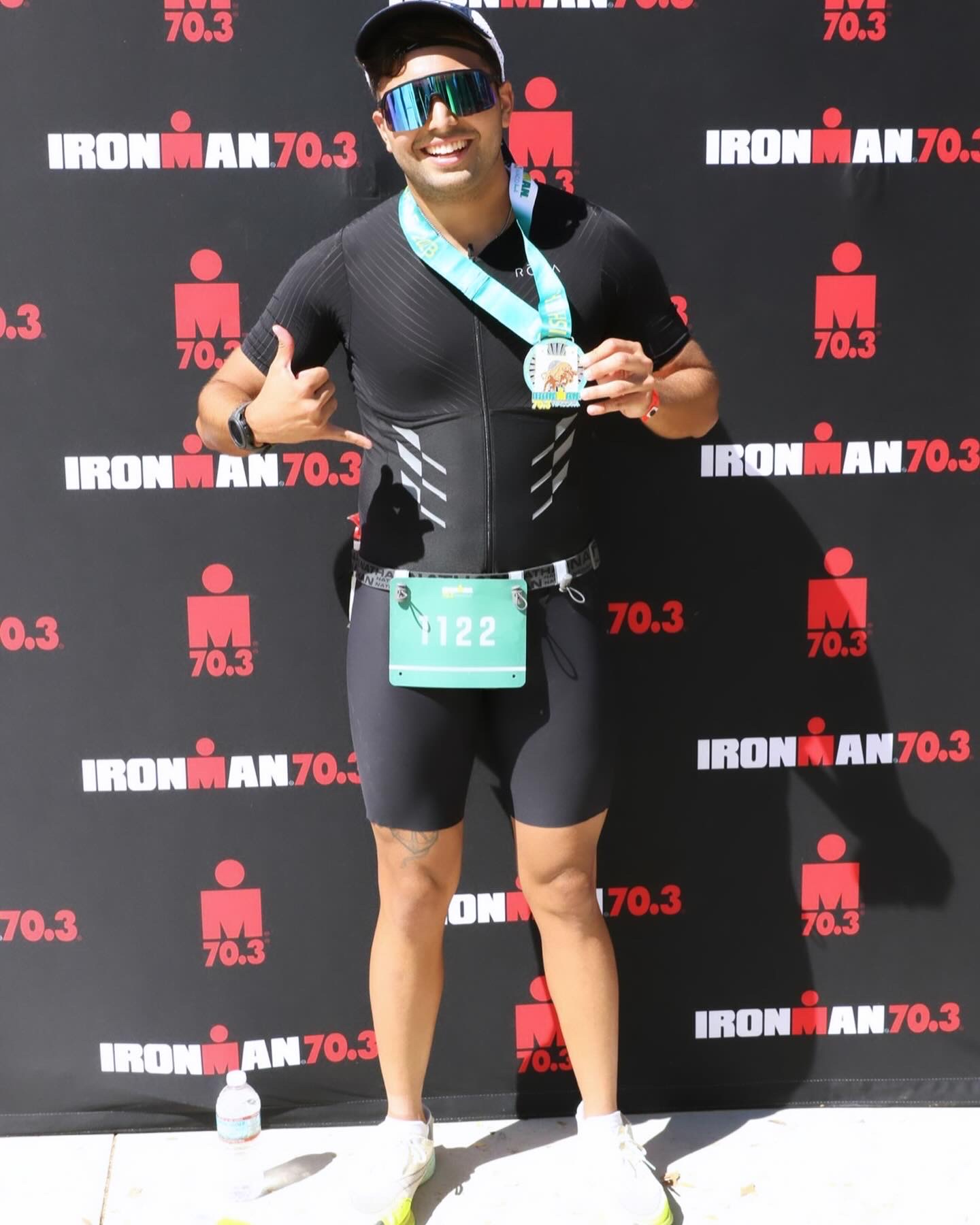 Javier Echeverria at Ironman 70.3 finish line holding his medal